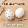 Zwölf ausgeblasene Enteneier mit weißer Schale: halbfertig gestaltetes Ei mit feiner Punktmalerei neben einem unbemalten Produktbild-Vorschau