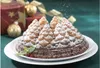 A Christmas-themed bundt cake shaped like a pine forest, dusted with powdered sugar, and decorated with mint and cranberries, set against a backdrop of wrapped gifts and ornaments. Anteprima dell’immagine prodotto