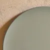 A close-up view of a round, khaki-colored table with a textured, light beige wall in the background. Anteprima dell’immagine prodotto