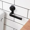 A black toilet paper holder mounted on a white tiled wall next to a toilet. Produktbild-Vorschau