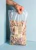 A hand holding a large bag of gummy worms. Produktbild-Vorschau