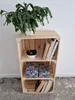 A wooden crate shelf unit with a plant on top and decorative items and books on the shelves. Produktbild-Vorschau