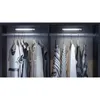Closet interior with clothes hanging on a rod, illuminated by LED lights. Produktbild-Vorschau