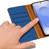 A hand is shown interacting with a blue and brown flip case for a smartphone. Produktbild-Vorschau