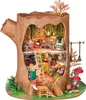 A miniature, intricately detailed treehouse model inside a hollowed-out tree trunk, complete with furniture, plants, and accessories. Podgląd zdjęcia produktu