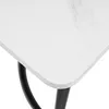 A close-up view of the corner of a white table with a marble-like pattern and black legs. Anteprima dell’immagine prodotto