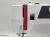 A close-up view of the side of a white sewing machine with red accents and some diagrams printed on it. Náhľad obrázku produktu