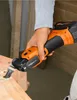 A person is using a cordless oscillating multi-tool to cut into a wooden surface. Náhľad obrázku produktu