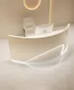 A modern reception desk with a computer and chair in a clean, minimalist setting. Voir les images du produit