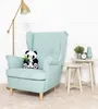 A plush panda toy sits on a light blue armchair next to a floor lamp and side tables. Produktbild-Vorschau
