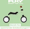 A light green balance bike with black seat and wheels, set against a solid light green background. Text overlays are present at the top and bottom of the image. Anteprima dell’immagine prodotto
