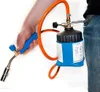 A person holding a gas torch connected to a gas canister clipped to their jeans. Voir les images du produit