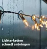 String lights are attached to a window with suction cups on a rainy day. Anteprima dell’immagine prodotto