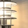 A close-up view of a modern outdoor wall lamp with multiple tiered shades. Produktbild-Vorschau