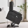 A gray recliner chair is shown from the side, tilted upwards on its mechanical base. The chair has side pockets containing remotes. A plant and a white cabinet are visible in the background. Náhľad obrázku produktu