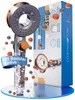 A shower head and its packaging are displayed, with small colored balls floating around them. Produktbild-Vorschau