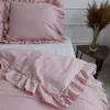 A close-up view of pink bedding with ruffles, including a pillow and duvet cover, on a bed. Náhled obrázku produktu