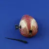 A vintage tin toy bird with a winding key and a separate black pointed object on a blue background. Produktbild-Vorschau