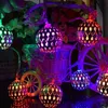 A string of decorative lights with spherical, patterned bulbs in various colors, set against a dark, floral background with a small decorative wheel. Produktbild-Vorschau