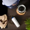 A coffee filter and coffee beans are arranged on a wooden surface, with a water filter pitcher in the background. Produktbild-Vorschau
