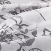 A close-up view of a white fabric with a gray floral pattern. Produktbild-Vorschau
