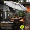 An outdoor patio scene with a large cantilever umbrella set up over a table and chairs. Voir les images du produit