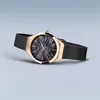 A rose gold watch with a black mother-of-pearl dial and a black mesh strap, shown at an angle against a plain light gray background. Podgląd zdjęcia produktu