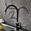 A black flexible kitchen faucet with silver accents is shown in a kitchen sink area against a grey stone-like backsplash. Náhľad obrázku produktu