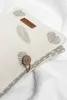 A close-up of a fabric organizer with a leaf pattern and a leather tag. Produktbild-Vorschau