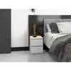 A bedside table next to a bed in a bedroom. Voir les images du produit