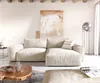 A modern living room with a large beige sectional sofa, abstract art on the wall, and a unique wooden coffee table. Produktbild-Vorschau
