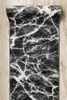 A rolled-up rug with a marble pattern is placed on a wooden floor. Voir les images du produit