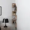 A corner shelf unit with decorative items and books, next to a nightstand with a lamp. Produktbild-Vorschau
