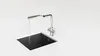 A modern kitchen sink with a chrome faucet running water. Podgląd zdjęcia produktu
