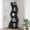 A black, wavy corner shelf unit is displayed against a light gray wall, adorned with various decorative items and two framed artworks on the wall. Podgląd zdjęcia produktu