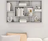 A gray floating shelf with books and decorative items on a white wall, with cushions on a sofa visible below. Voir les images du produit