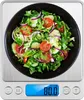 A digital scale with a bowl of salad on top. Produktbild-Vorschau