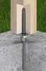 A close-up view of a wooden post anchored to a concrete base with a metal bracket and bolt. Náhľad obrázku produktu