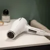 A white hairdryer is placed on a white surface with a green wall in the background. Náhľad obrázku produktu