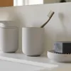 A bathroom shelf with a soap dispenser, toothbrush holder, and soap dish. Produktbild-Vorschau