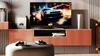 A modern living room setup with a TV, gaming console, and controllers. Produktbild-Vorschau