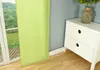 A close-up of a green curtain hanging next to a white dresser with a vase of flowers on top. Produktbild-Vorschau
