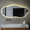 A modern bathroom with a marble sink and a uniquely shaped LED mirror. Produktbild-Vorschau
