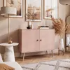 A stylish living room scene featuring a pink cabinet, side table with a cup of coffee, and decorative elements. Produktbild-Vorschau