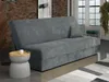 A modern living room with a gray corduroy sofa bed, a side table with a mug, and a rug.