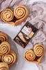 A top-down view of cinnamon rolls and a packet of RUF Tonka Zucker with real vanilla. Produktbild-Vorschau