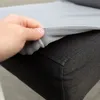 A hand is shown lifting a gray fabric cover from a dark gray upholstered surface. Náhled obrázku produktu
