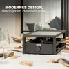 A raclette grill is set up on a dining table, ready for use, with cutlery and glasses nearby. Produktbild-Vorschau