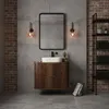 A modern bathroom vanity with a wooden cabinet, white sink, and mirror, set against a brick and concrete wall. Náhled obrázku produktu