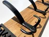 Close-up of black metal hooks mounted on a wooden board. Produktbild-Vorschau